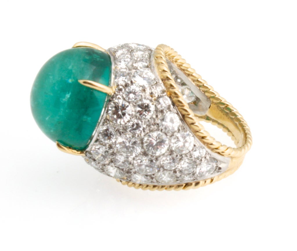 This decadent vintage Van Cleef & Arpels cocktail ring features a gumdrop size cabochon emerald that weighs approximately 13.50 carats. It's enveloped by approximately 6 carats of beautifully matched pave set diamonds. This showstopper is made to be