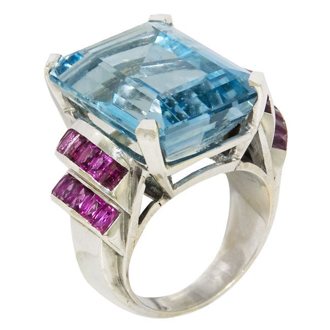 Art Deco ring, 14K White Gold set with a Gem Color Aquamarine of approximately 25 Carats and further accented on the sides with fancy cut Baguette Rubies. Finger size = 7 1/2