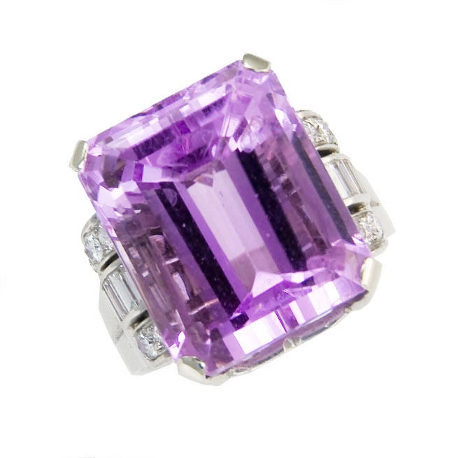 Platinum Ring containing a step cut Kunzite of approximately 20 Carats and Further Accented with Round and Baguette Diamonds. Finger size = 7 1/2