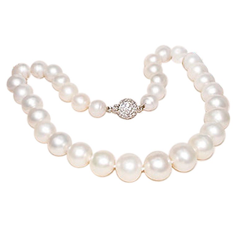 Cartier signed and Numbered 17 inch Cultured Pearl necklace with Platinum and Diamond Pave Ball Clasp, Pearls measuring from 11 to 15 M.M. Please contact us for further information Details.