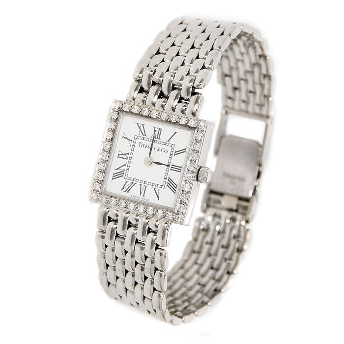 Ladies 14K White Gold Tiffany & Company Quartz watch with Intigrated Link Bracelet and Diamond Bezel, White dial with Black Roman Numerals.