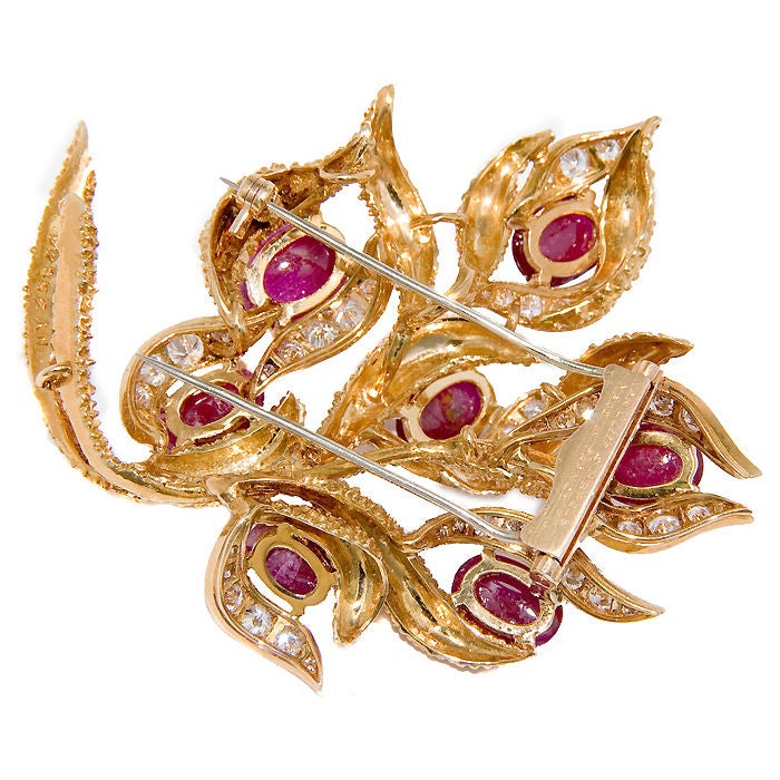 18K yellow textured Gold, Clip Brooch by Van Cleef & Arpels, set with 7 Cabachon Burma Rubies approximately 8 Carats total and Round brilliant cut Diamonds totaling 1.70 Carat.