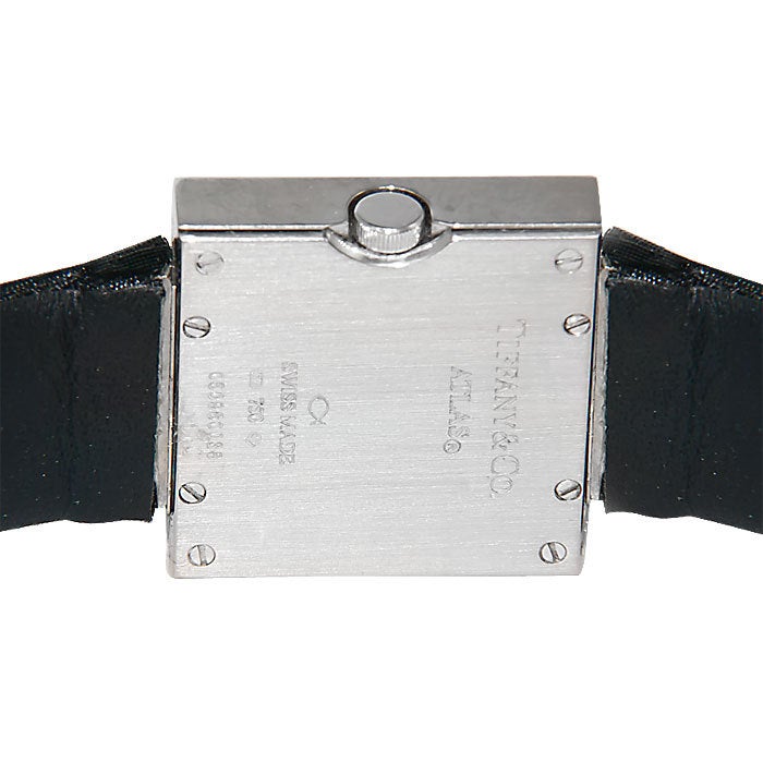18K White Gold Wristwatch from the Atlas Collection. Square case with Diamond set Bezel, Swiss Quartz Movement, Black Dial with Raised White Gold Markers. Black Satin Finished Strap with White Gold and Diamond set Buckle. $16,000.00 Retail.