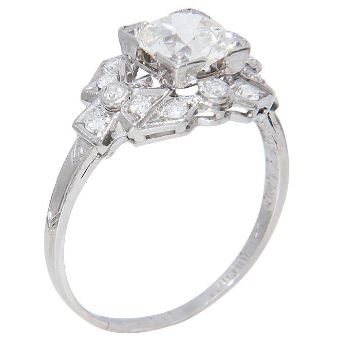 Fine Edwardian Engagement ring, Platinum Mounting with Miligrain and Hand Engraved Details, centrally set with a 1.36 Carat Old European cut Diamond, K Color and SI1 Clarity. Open Culet with very good proportions.The mounting is further set with