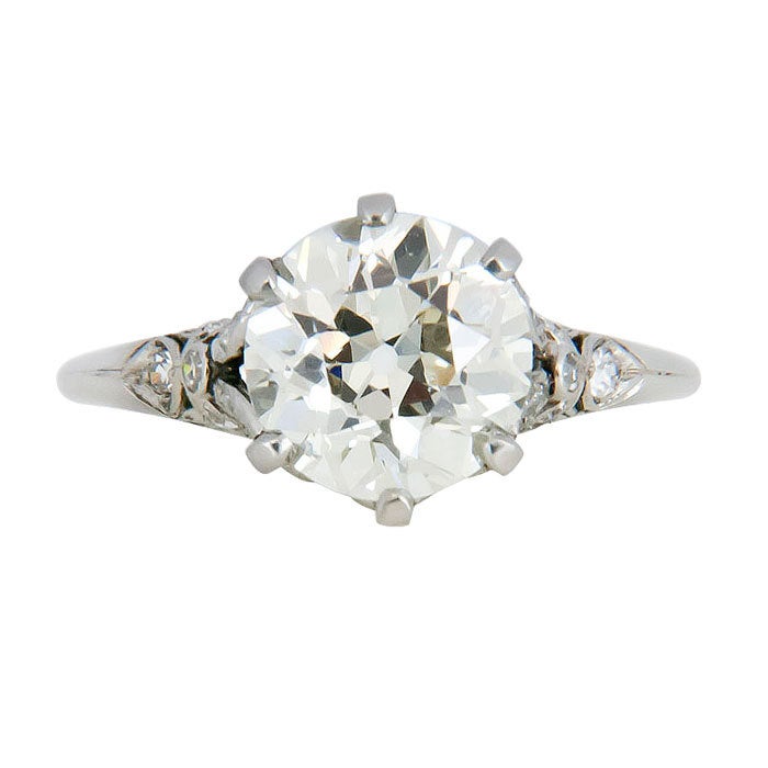 Circa: 1920s all original Platinum and Diamond Engagement Ring, centrally set with a 2.96 Carat European Cut Diamond that is L Color and VS 2 Clarity. Platinum Mounting with open work designs, further set with small accent diamonds. Center stone is
