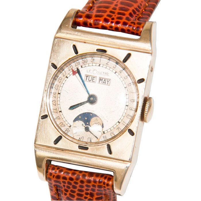 LeCoultre, yellow gold-filled rectangular triple-calendar moonphase wristwatch, silvered dial with blued steel hands, two apertures for day and month, outer ring for date with red arrow hand, 17-jewel manual- wind movement, circa 1950s, brown