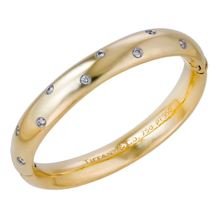Tiffany & Company 18K Yellow Gold and Diamond Bracelt from the Etoile Collection, Containing 10 Platinum Bezel set Round Brilliant Cut Diamonds weighing a total of .60 Carat. Inside Diameter measures 5 1/2 Inches.