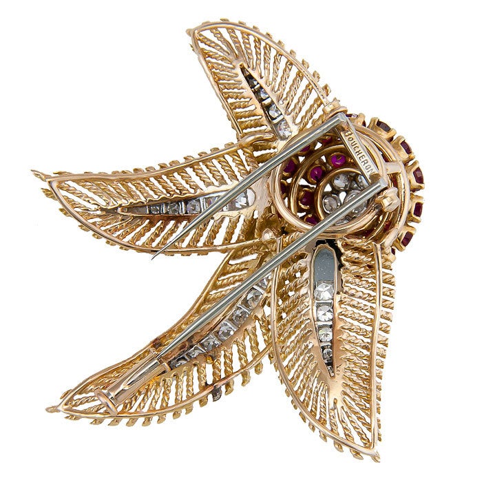 Elegant Clip Brooch in 18K yellow Gold signed by Boucheron, set with Fine color Rubies and Round Brilliant cut Diamonds totaling one Carat.