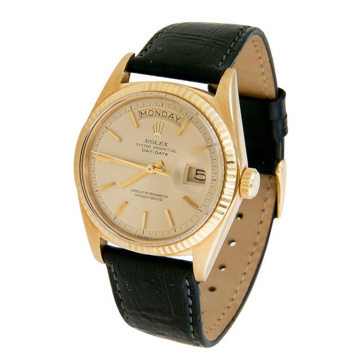 Extremely clean Rolex Day-Date President, Ref.1803. 18k yellow gold case, fluted bezel, automatic movement. Gilt dial with raised baton indexes. Rolex buckle, new textured strap.