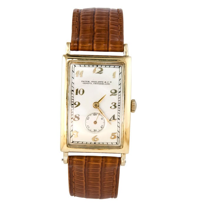 Large Patek Philippe curved hinged rectangular wristwatch in 18k yellow gold, circa 1920s. 18-jewel manual-wind movement, silvered dial with raised gold Breguet numerals. Signed and numbered case and movement.