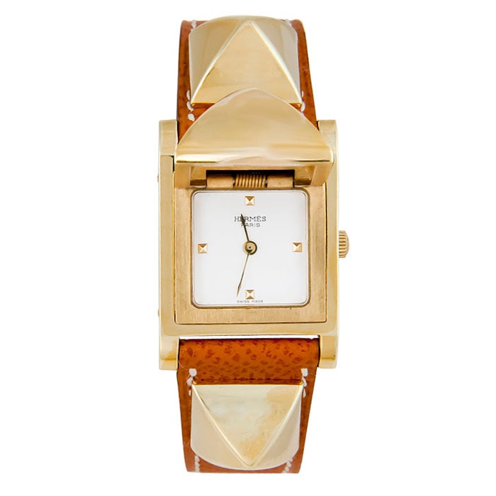 Medor wristwatch, gilt metal case and fittings. Circa 2005. New dark tan leather strap with white stitching. Quartz movement, white dial.
