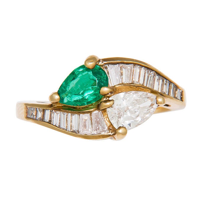 18K Yellow Gold Bypass Ring set with a Pear Shape Diamond and Pear Shape Emerald. Diamond total = 1.00 Carat with the Pear shape being .65 Carat. Diamonds are G in Color and VS in Clarity. Emerald is of very fine color.  Finger size = 7