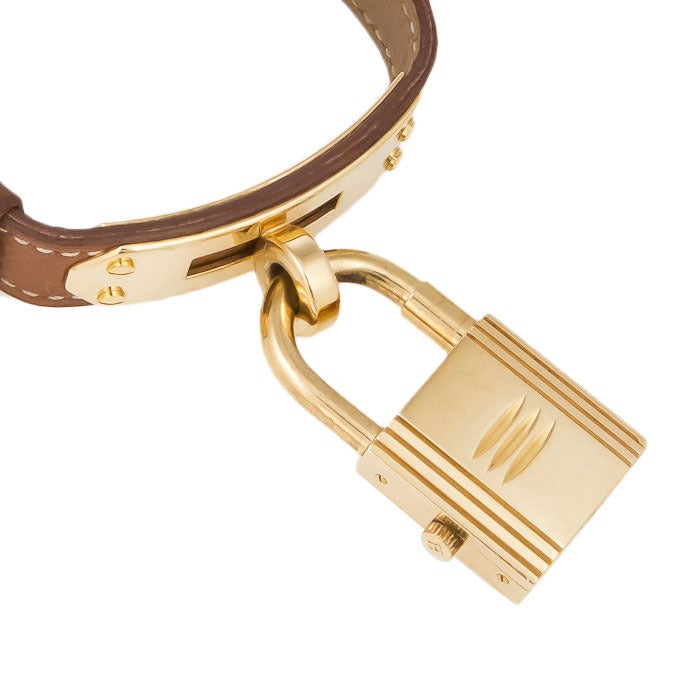 Hermes gilt metal Kelly lock wristwatch on a brown strap. Quartz movement, 7 1/2 inch strap.