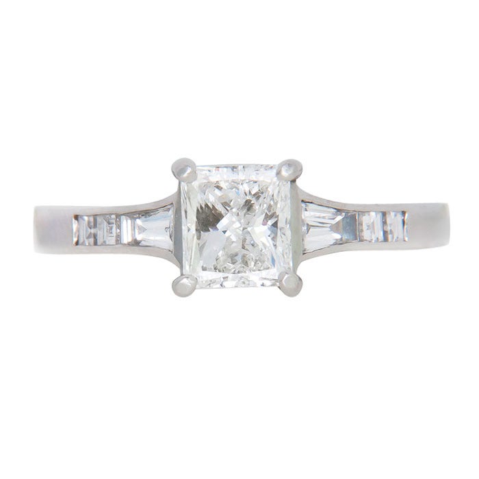 Platinum Engagement Ring by Jeff Cooper, the sides feature Tapered Baguette and Square cut Diamonds. Centrally set with a G.I.A. Certified 1.01 Princess cut Diamond that is G in Color and SI1 in Clarity. Finger size = 6 1/2