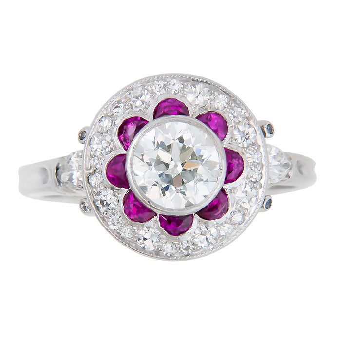 Circa: 1930  Platinum Ring, centrally set with an Old European Cut Diamond that is just under 1 carat, .96-.98 by measurement There is an outer ring of small old cut Diamonds and two Pear shape Diamonds one on either side of the Shank that total .70