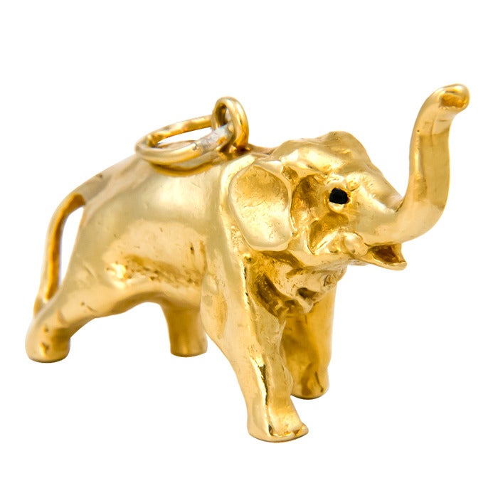 Circa:  1980 18K yellow Gold, heavy Elephant charm, Nicely detailed and set with Sapphire Eyes.