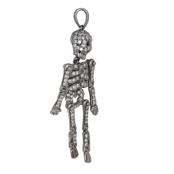 Circa: 2010 14K white gold with a gray Rhodium finish Skeleton pendant, arms and legs are articulated at the joints as is the body and head. Set with 1 carat of Diamonds.