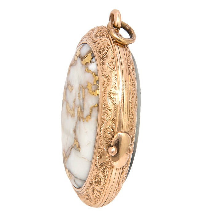 Circa: 1900 14K yellow Gold Locket set with a sizable piece of Gold Quartz and Moss Agate on the reverse side. Hand Engraving work on both sides and containing pictures from a later date.