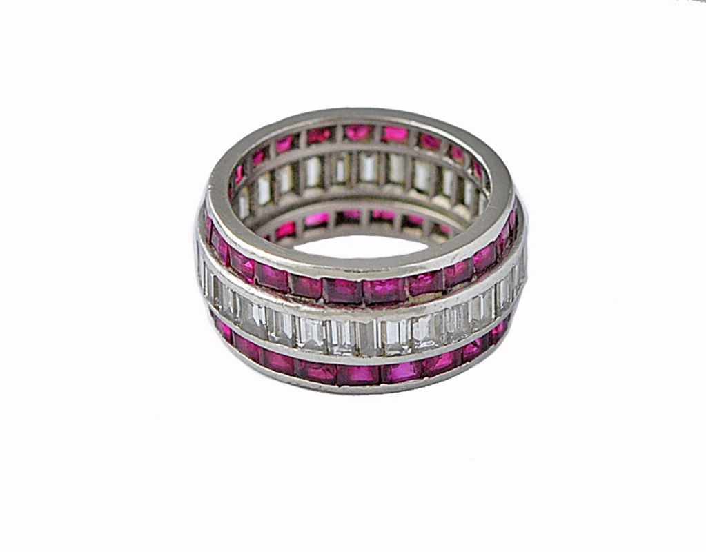 A beautiful Art Deco band made of platinum, set with a row of  diamond baguettes bracketed by two rows of square rubies. This ring is a fabulous example of the timeless beauty of the Art Deco period.