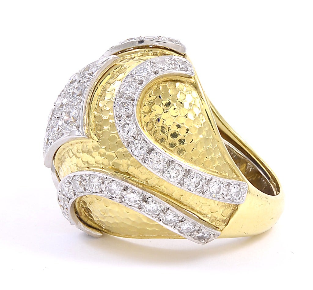 A fabulous 18k gold ring designed by David Webb featuring a yellow gold domed ring with a hammered texture embellished with approximately 2&1/2 carats of diamonds set in white gold. The ring is a size 6&1/2 and is easy to size.