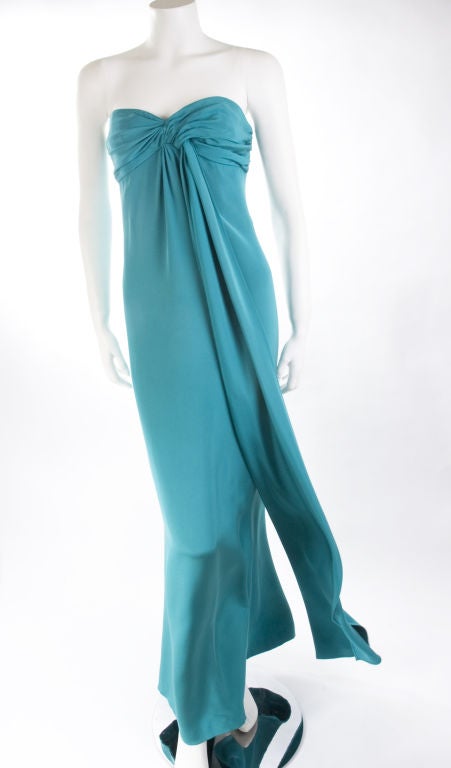 1987 Yves Saint Laurent Evening Gown in emerald green.<br />
The pin comes with the dress but is not original YSL just goes well with it.<br />
It is in very good vintage condition.<br />
Measurements:<br />
Length: back middle 51” - Bust: 34” -