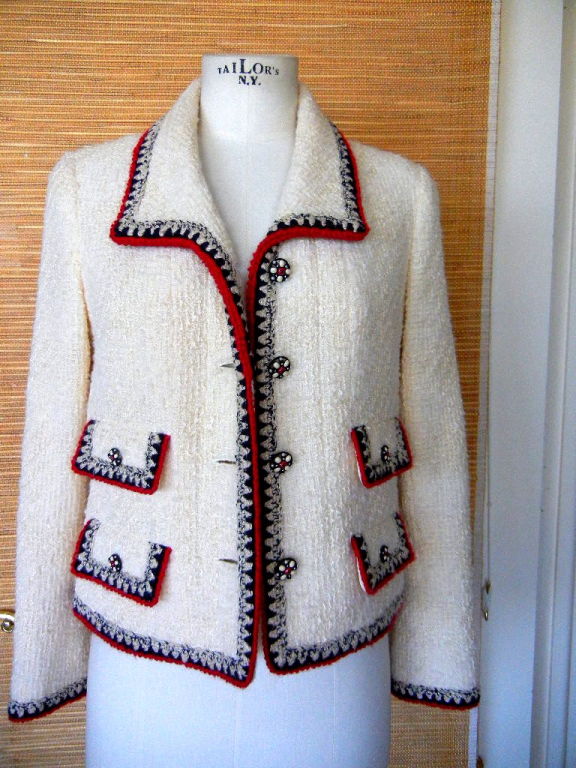 This imporant CHANEL jacket is a reintroduced design and is highly collectable.<br />
<br />
Ivory with beautifully detailed accents.<br />
4 flap pockets with working buttons and 2 working buttons on each cuff.<br />
Each button is a thin black