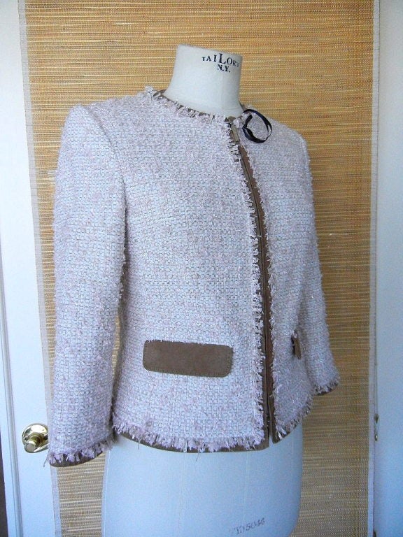 Pale pink and winter white fantasy tweed short jacket.
3/4 Sleeve edged in a small fringe and accentuated with a touch of metallic.
Mocha brown suede trim and flap pockets.
Rounded neck with a zipper closure.  Pockets close with hidden snaps.
Chic