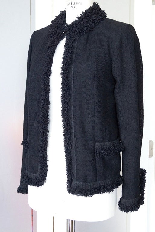 Guaranteed authentic CHANEL 03C fabulous black jacket with wonderful light texture.
Entirely trimmed in a lush woven trim binding.
The boucle creates a sort of mandarin collar with one button at the neck. 
2 patch pockets and 3 buttons with snap