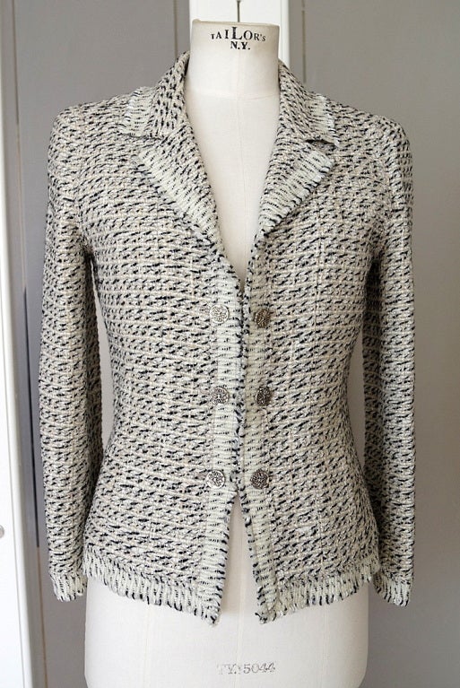 Guaranteed authentic CHANEL 04A  sensational tweed jacket with beautiful  details! 
Stunning bone and black fantasy tweed jacket with fringed edge.
Hint of taupe throughout. 
Single breast 3 french cuff buttons held together by a chain.
Each