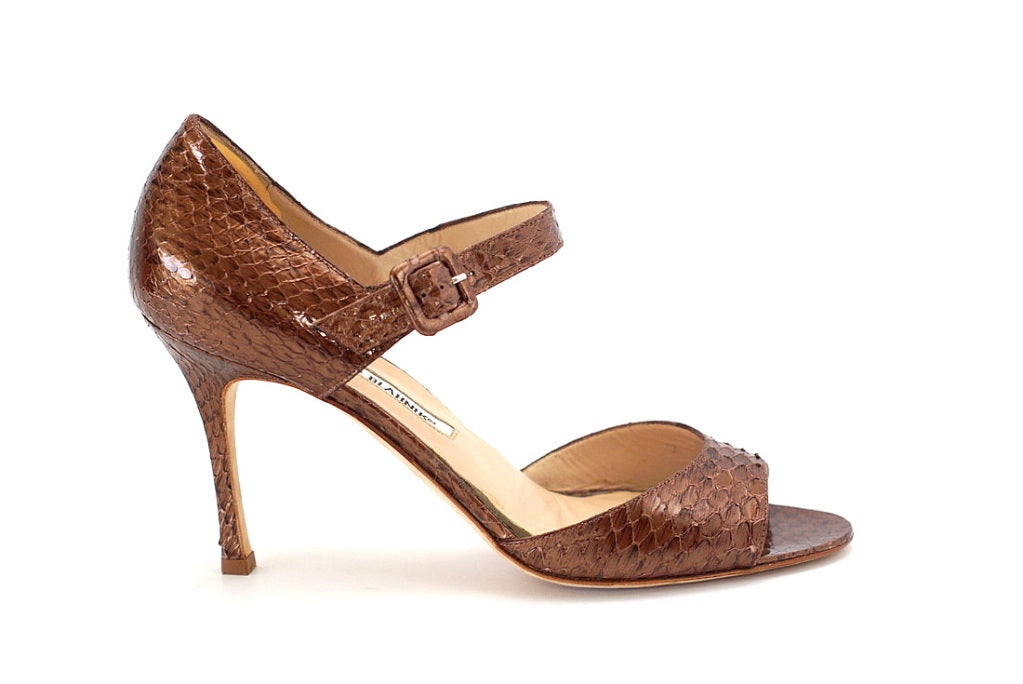 Gorgeous copper colour python that is utterly neutral.
Open toe, open sides and a Mary Jane style strap.
Buckle is also snake covered.
Signature heel.
Worn one time only indoors.
Pad put in underneath inner lining for comfort.  You can have