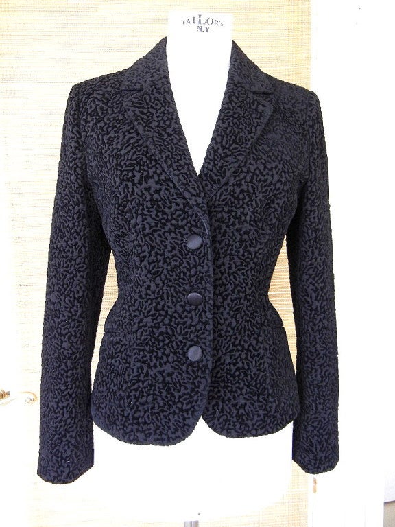 The fabric is divine and very unique.
Flocked black velvet pattern atop a dimensional background creates a Persian lamb effect. 
Single breasted 3 button short jacket.
Notch lapel. 
3 buttons on each cuff.
All buttons are black satin.
2 angled