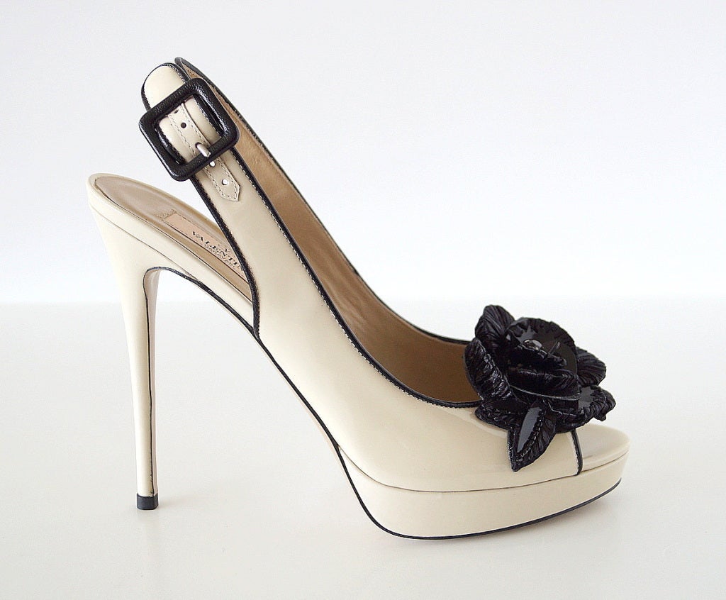 Guaranteed authentic VALENTINO patent leather slingback with fabulous flower. 
Cream patent slingback platform with black patent edging.
Large black flower constructed of large paillettes with a center black diamante and rafia details on some