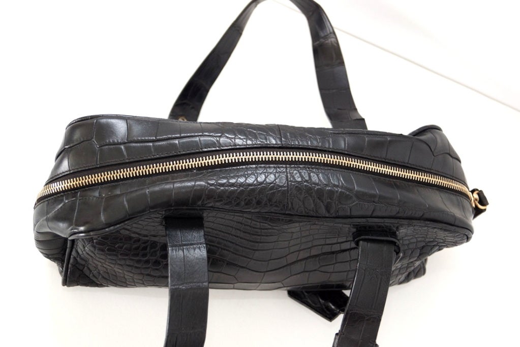 Terrific PRADA matte black crocodile bag with gold hardware. 
2 flat straps with buckles embossed PRADA.  
Top zipper opens all the way around for easy access.  
The interior is lined in black satin with a zipper pocket. 
Comes with lock, keys