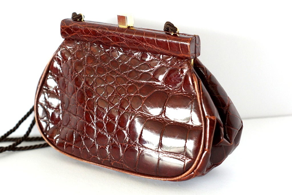 Rich cognac Crocodile Vintage top frame bag. 
Worn either as a clutch, shoulder or cross body bag, this is versatility at its best. 
Long twisted rope strap. 
Small gold square embossed PRADA at the top for closure. 
The interior is lined in