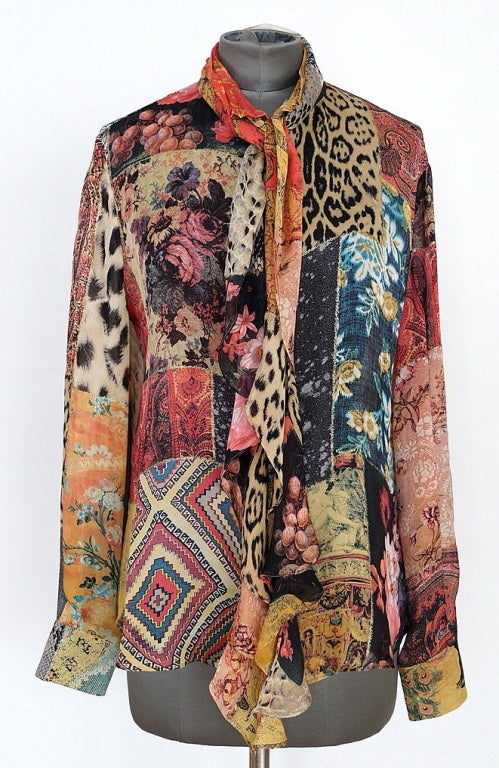 Semi sheer silk chiffon blouse with exotic prints of snake skin, leopard, flowers and baroque designs .
Two long ties that fall with undulating ruffled edges and can be worn a myriad of ways.
A soft metallic sparkle runs throughout the shirt but