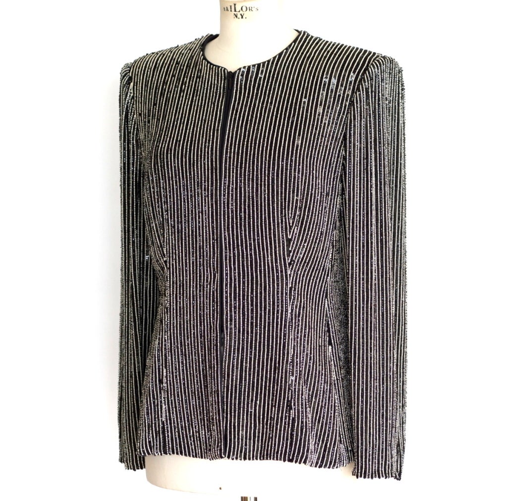 Guaranteed authentic Giorgio Armani beaded jacket. 
Striking in black and white pinstripe.
No collar, no pockets with sleek beautiful shaping.
Unique hidden zipper closure.  Easily worn open or closed.
So beautifully made that it could be reversible