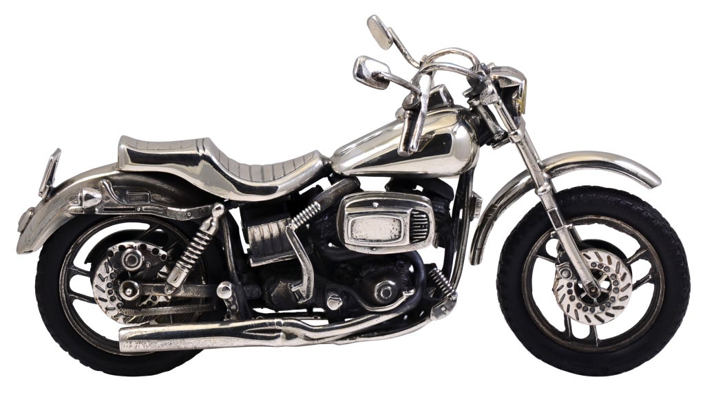 Rare figural motorcycle made in sterling silver, with continental silver marks and English export markings. The rubber wheels are removable. This is a replica of a Harley Davidson, complete with movable kick stand. The front wheel and handle bars