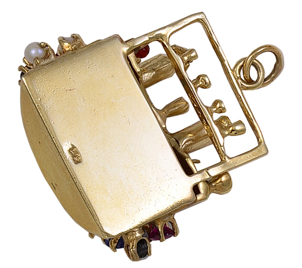 Large gem-set bar charm set in 14k gold. Glasses and cocktail shakers are placed on the bar. The bar is set with faceted rubies, sapphires and pearls.
Three-dimensional. A  cheerful addition to a bracelet with large charms.
