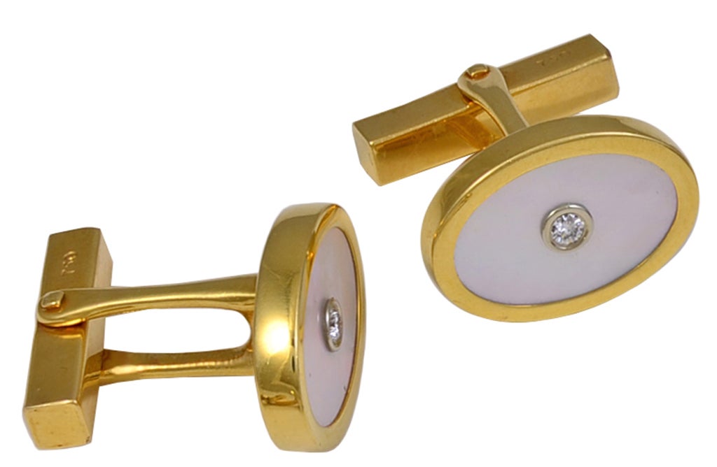 Elegante Manschettenknöpfe aus 18 Karat Gold mit Perlmutt von Tiffany&Co. Facettierter Diamant in der Mitte, gefasst in Platin.
Der perfekte Manschettenknopf zum Anziehen.