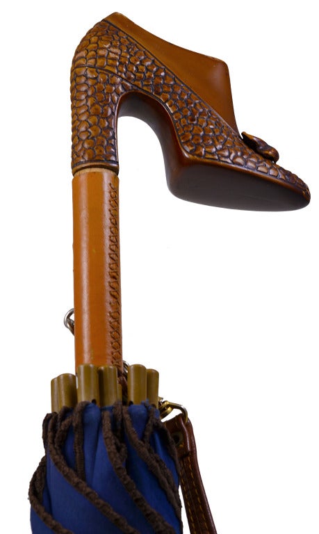 Rare Maud Frizon Paris umbrella with figural carved detailed shoe as a handle. Very unique and fashionable in a lovely shade of blue with brown piping to match the handle. Has detachable strap for easy carrying. So very chic.