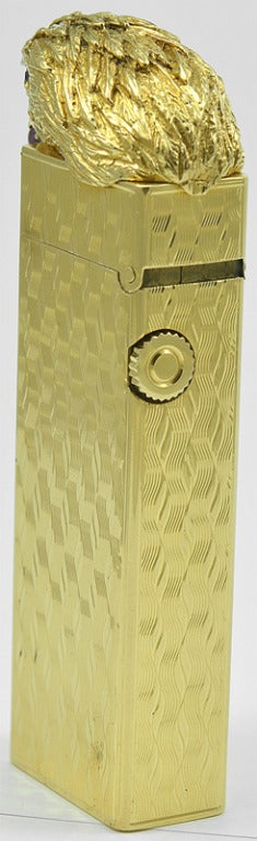 Extraordinary 18K gold cigarette lighter, made and signed by Dunhill. Figural eagle's head perched atop the lighter. Beautiful gold textured life- like feathers; bright faceted emerald eyes; a large cabochon ruby in its beak. This is gorgeous and