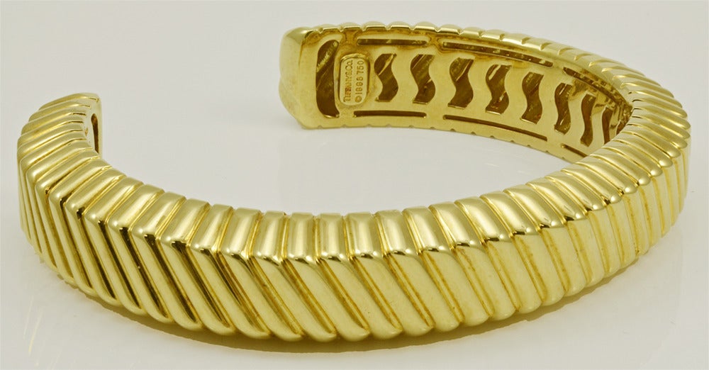 Elegant heavy 18k gold cuff, made and signed by Tiffany & Co. The entire bracelet, top and sides, is deeply engraved in a diagonal line pattern.  This design catches the light; the bracelet shimmers and sparkles.  The interior is   beautifully