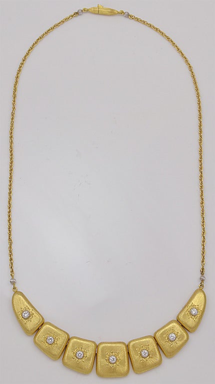 Elegant 18K yellow gold necklace made and signed by Buccellati. Comprised of seven distinctive brushed-gold plaques. Each set with a full cut diamond in a 