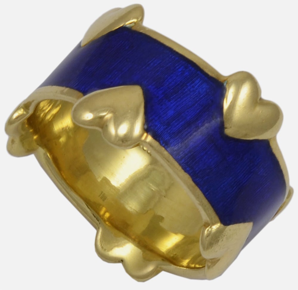 Most eye catching 18kt gold ring made by Schlumberger for Tiffany & Co. The wide cobalt blue enamel band is set with gold hearts around the borders.

Unusual design, a very romantic ring. Size 7.