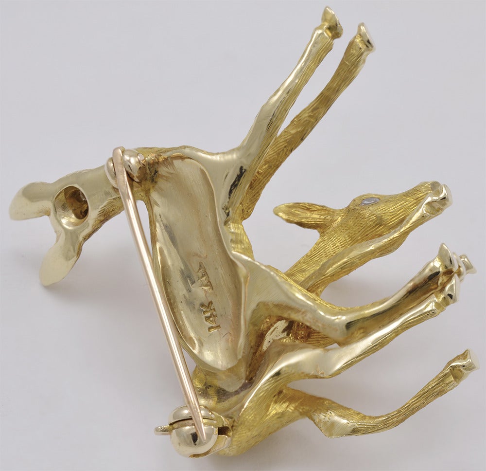 Two adorable figural fawns, set in 14K brushed gold with brilliant diamond eyes.
One is grazing and one is gazing. A most charming piece of jewelry.