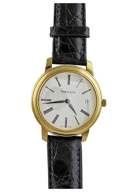 Very handsome 18K gold Tiffany & Co mens watch.Prominent lugs. Roman numerials,with date on the dial.<br />
Quartz, Swiss movement