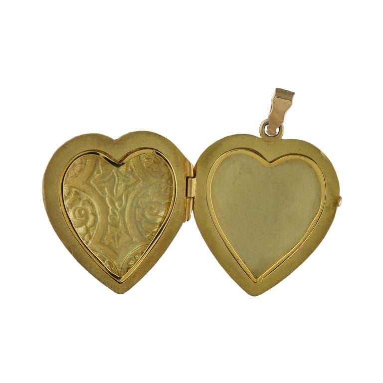 Outstanding large heart shaped locket.Beautifully green enameled with flowers and leaves. Opens and holds two pictures with bezels. Very early and unusal in color and quality