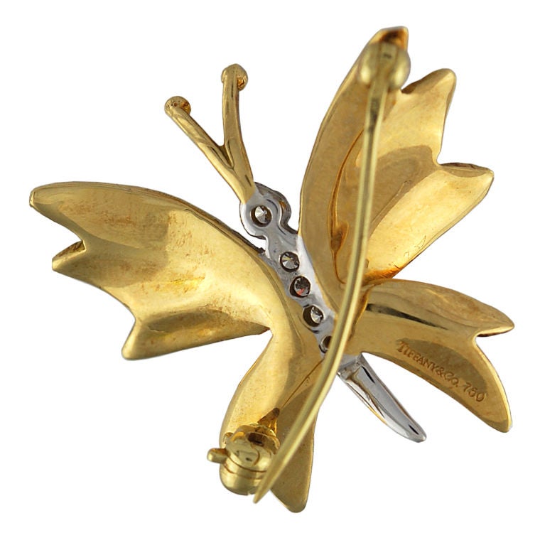 Figural 18K gold butterfly pin with diamond head and body.<br />
Realistic detailing