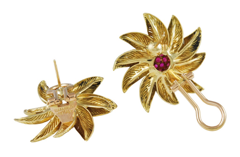 Tiffany & Co. 18K gold, textured flower earrings with faceted ruby centers.  Omega backs with posts.
Flower is highly dimensional and gives the impression of movement.  Approximately 1 1/4