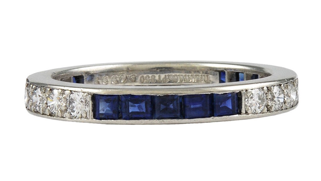 Tiffany & Co eternity band. Set in platinum. Alternating  brilliant sapphires and diamonds.Size 8 1/2